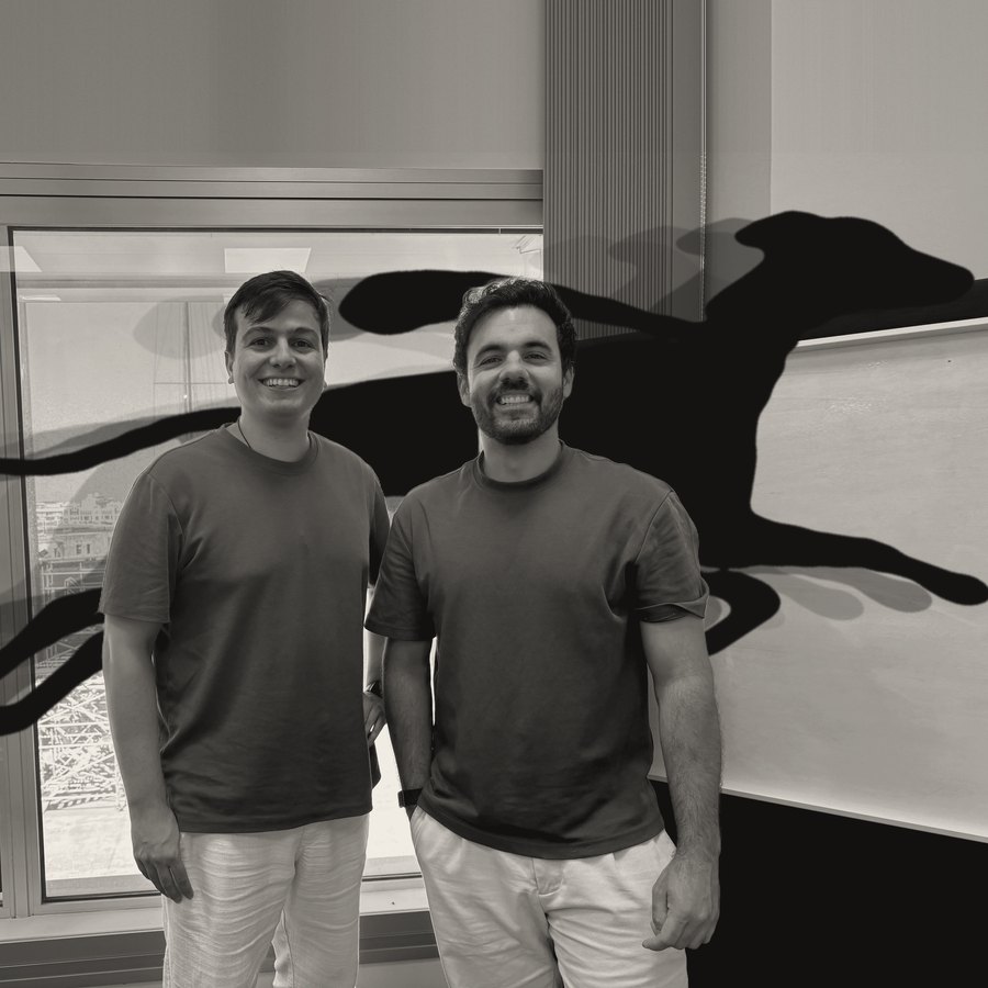 Los dos fundadores de Baker en su oficina junto al puerto, en blanco y negro, mientras el galgo de su logo salta por detrás de ellos dejando una estela.